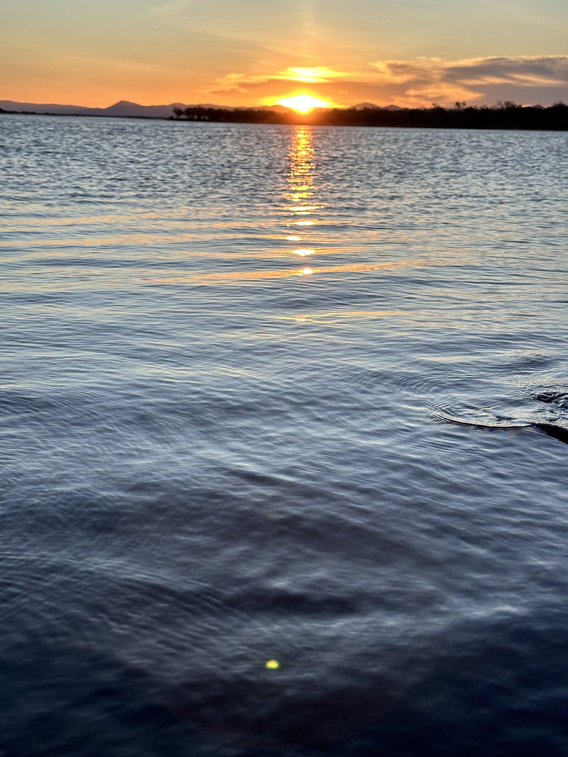 Sunset over the Zambezi River in Lower Zambezi National Park, Zambia, with the escarpment hills silhouetted behind