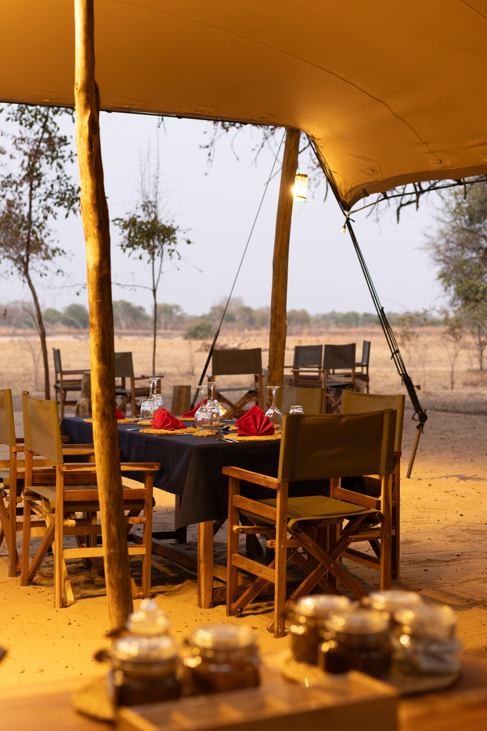 La tenda mensa in tela aperta sui lati e la tavola apparecchiata del Kutandala Camp, North Luangwa National Park