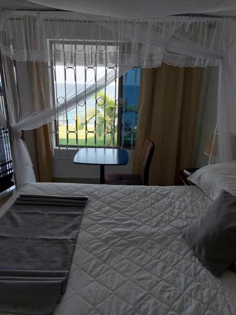 Ein Doppelzimmer mit drapiertem Moskitonetz in der Samfya Waterfront Lodge mit Blick über den Bangweulu-See