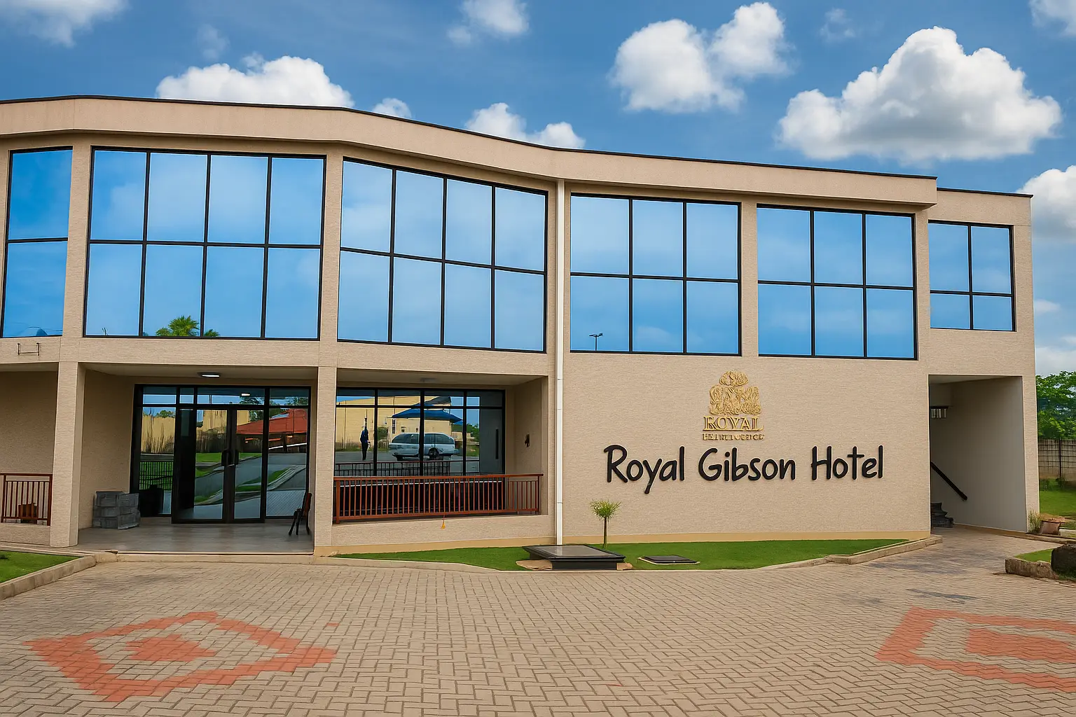 The two-storey glass-fronted exterior of the Royal Gibson Hotel in Kitwe, with its name and crest above the forecourt