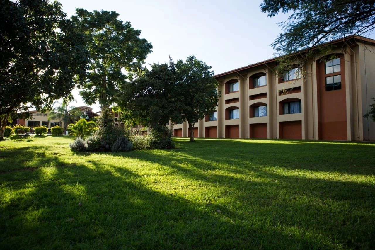 The arched two-storey guest wing and lawns at Mkango Golfview Hotel, Lusaka