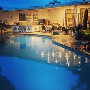 The swimming pool and poolside cafe terrace at Fawlty Towers, Livingstone, at dusk