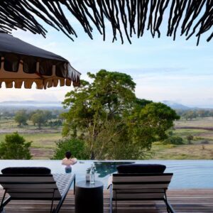 Der Infinity-Pool und das strohgedeckte Sonnendeck der Chichele Presidential Lodge mit Blick über das Luangwa-Tal