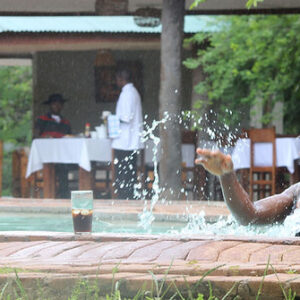 Der Swimmingpool und die schattige Terrasse zum Essen im Freien der Chimfule Lodge bei Mfuwe