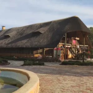 The main thatched lodge building and courtyard fountain at Liseli Lodge, Mongu
