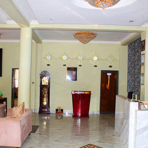 The marble-floored reception lobby of the Sherbourne Hotel in Kitwe, with a red front desk below a row of world clocks