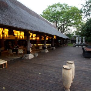 Open-sided thatched main building and timber deck with lounge seating at Mfuwe Lodge, South Luangwa National Park, Zambia
