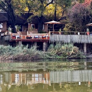 Thatched riverside buildings and a timber viewing deck at Tongabezi Lodge on the bank of the Zambezi River near Livingstone, Zambia