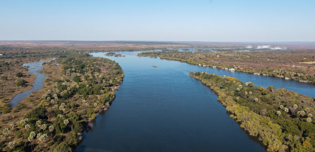 Aerial view of the broad Zambezi River braiding around wooded islands upstream of Victoria Falls